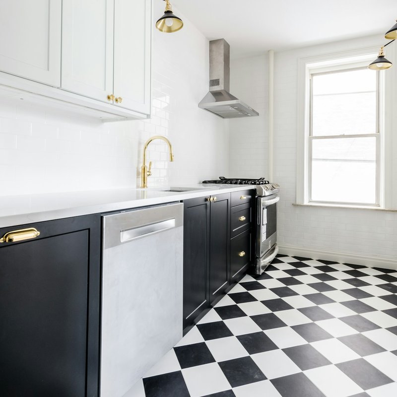 Vintage inspired kitchen with checkerboard flooring and gold accents