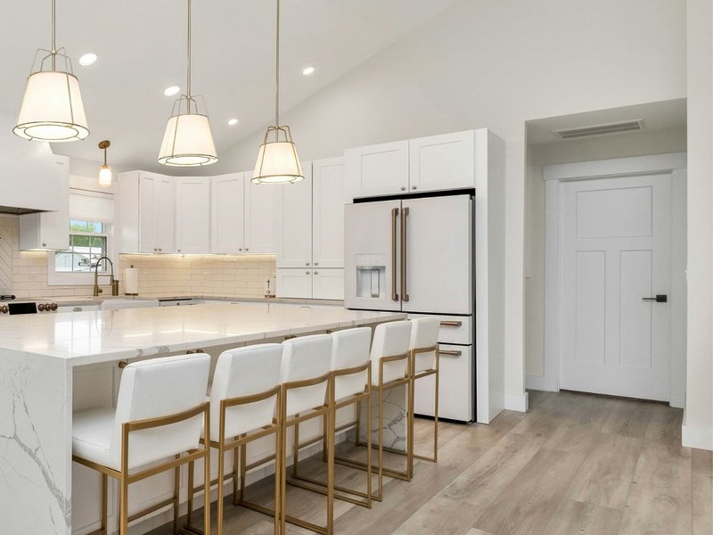 Stylish kitchen in Minneapolis with white marble countertops and light laminate wood look flooring